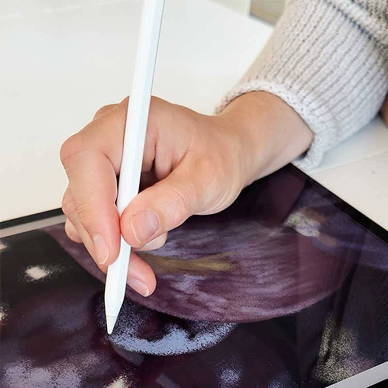Photo de Myriam Gabrielle en train de dessiner l'illustration culinaire sur les fruits d'automne : grains de raisin en gros plan